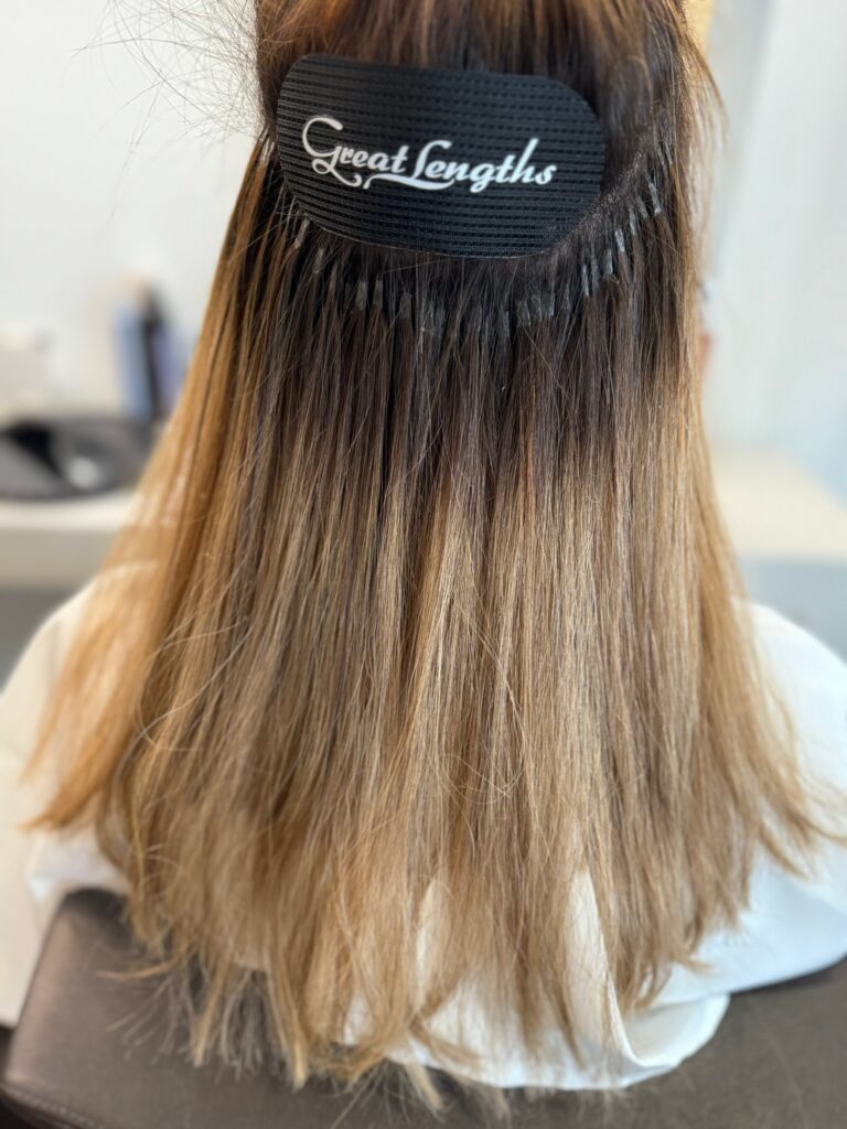 Nahaufnahme einer professionell eingearbeiteten Haarverlängerung mit Great Lengths – die feinen Bondings sind nahezu unsichtbar und perfekt ins Eigenhaar integriert.