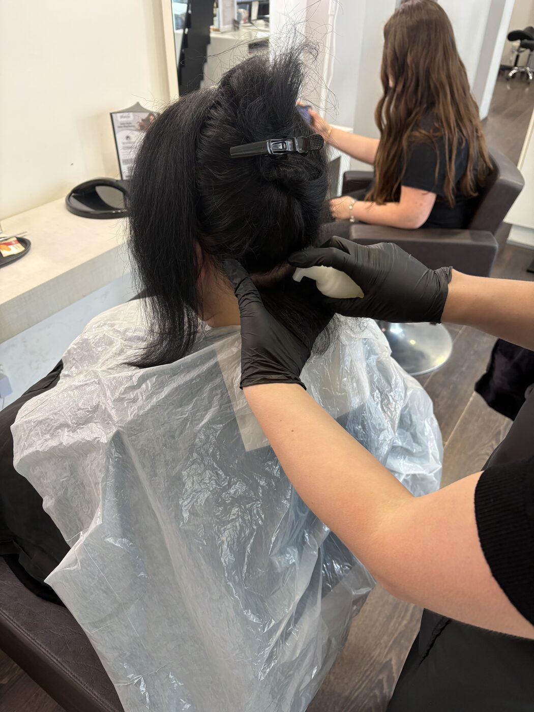 Vorbereitung der Keratin-Haarglättung: Haar wird partienweise abgeteilt und angefeuchtet